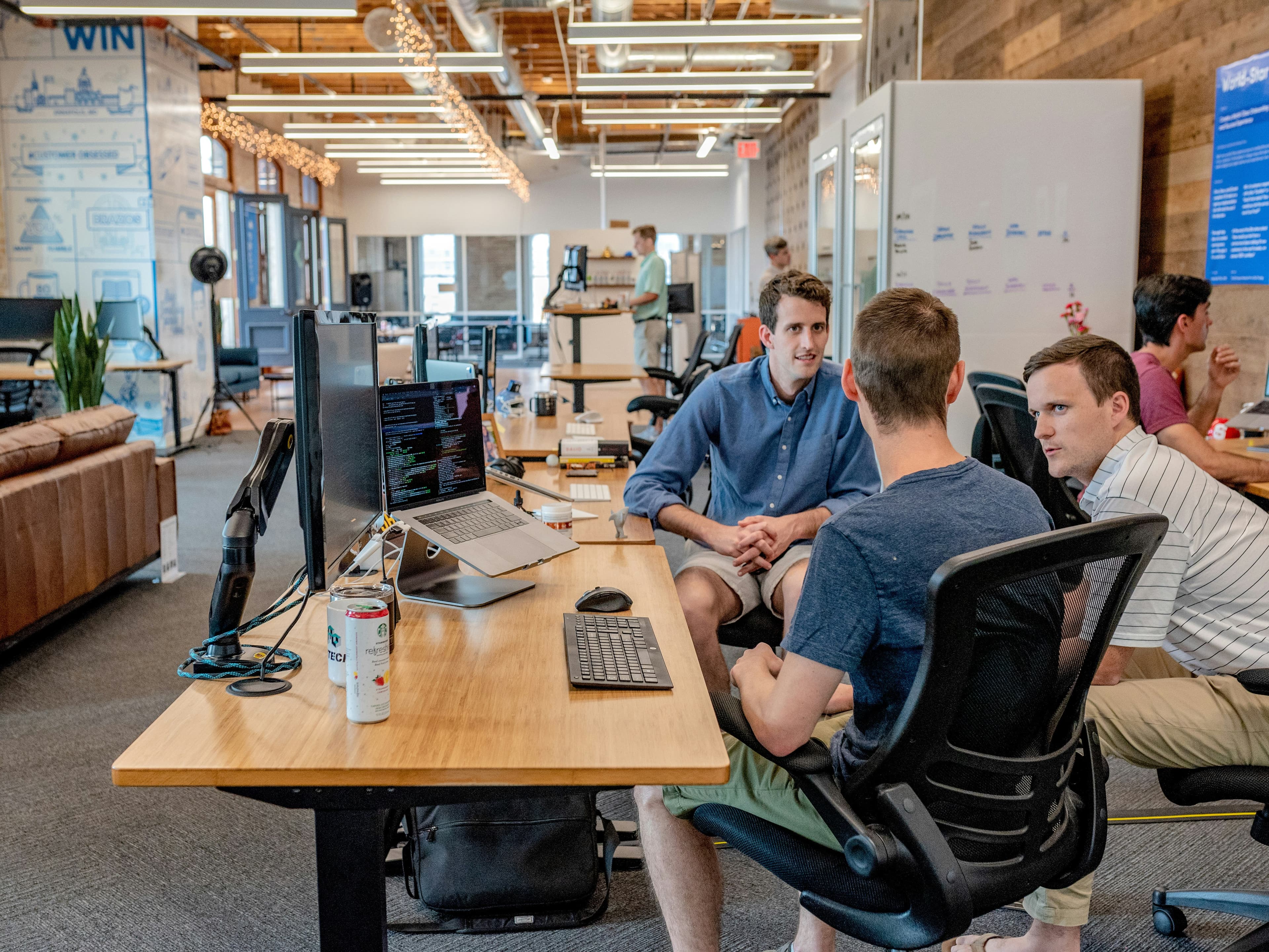 Sales team collaborating at desks in an open office environment reviewing AI CRM pipeline results